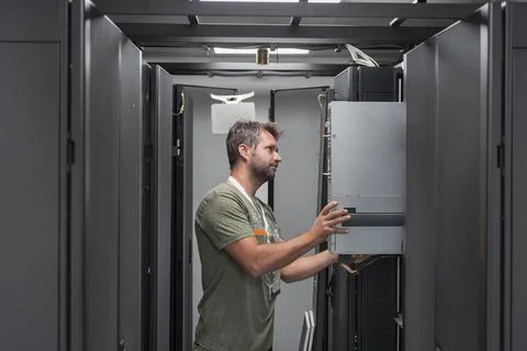 IT engineer working In the server room or data center The technician puts in a Stock Photos