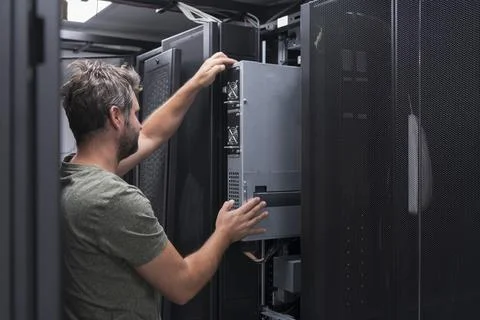 IT engineer working In the server room or data center The technician puts in a Stock Photos