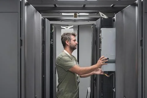 IT engineer working In the server room or data center The technician puts in a Stock Photos