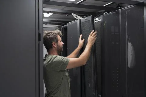 IT engineer working In the server room or data center The technician puts in a Stock Photos