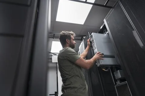 IT engineer working In the server room or data center The technician puts in a Stock Photos