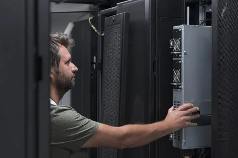 IT engineer working In the server room or data center The technician puts in a Stock Photos