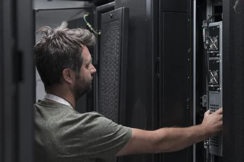 IT engineer working In the server room or data center The technician puts in a Stock Photos