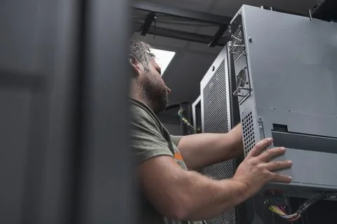 IT engineer working In the server room or data center The technician puts in a Stock Photos