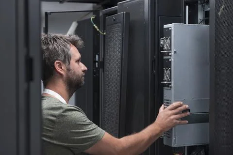 IT engineer working In the server room or data center The technician puts in a Stock Photos