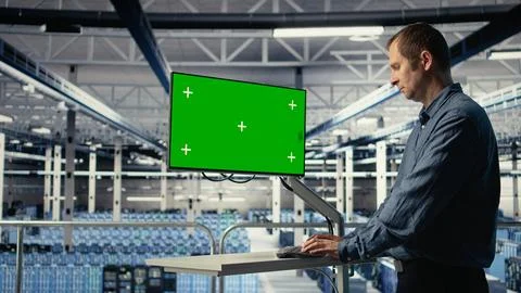 IT expert monitors server farm activity using green screen workstation Foto stock