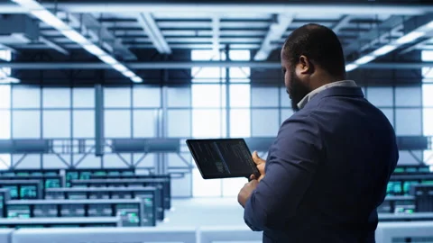 IT expert in server hub facility looking for network bugs with tablet Stock Footage 277644450