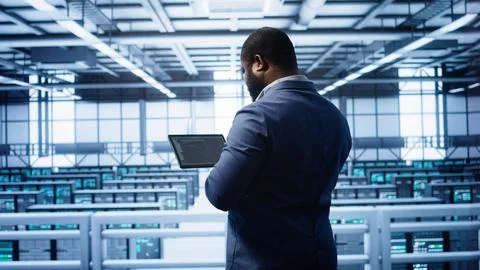IT expert in server hub facility looking for network bugs with tablet Stock Photos