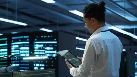 IT expert in server room tracking network traffic with tablet Stock Photos