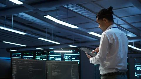 IT expert in server room tracking network traffic with tablet Foto stock