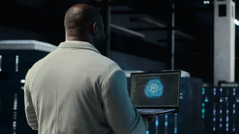 IT expert walking in server hub using laptop to enhance AI model accuracy Stock Footage 311833701