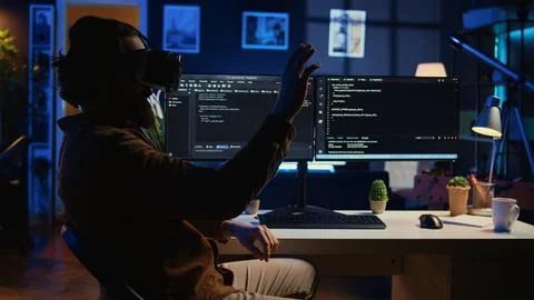 IT expert wearing high tech virtual reality headset to visualize lines of code Stock Photos