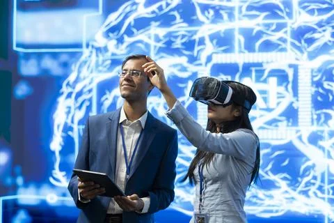 IT experts using VR headset, programming artificial intelligence model Fotos de archivo