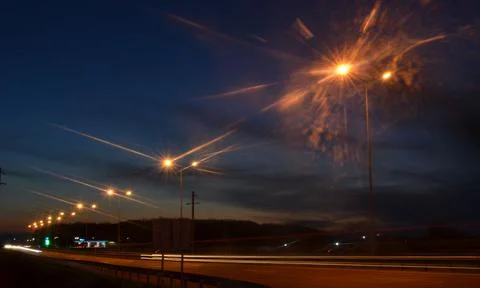 It is getting dark, night lights over the highway lit up. Stock Photos
