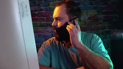 IT Guy From 1990's in Front of Computer Making Call on Old Flip Mobile Phone Stock Footage 301505443