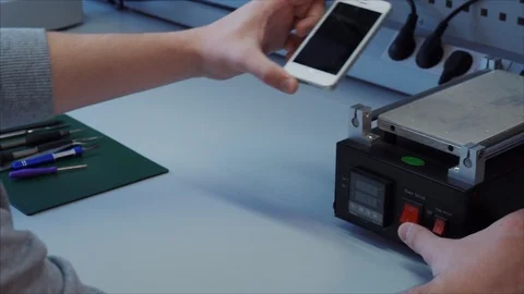 IT guy do maintenance a phone with a broken screen is placed on the heating 스톡 동영상 105971653