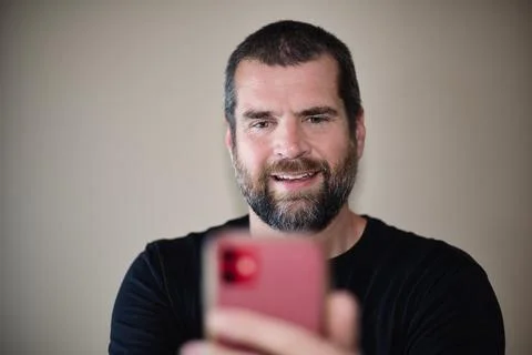 IT Guy Looking at Cell Phone - Smiling Foto stock