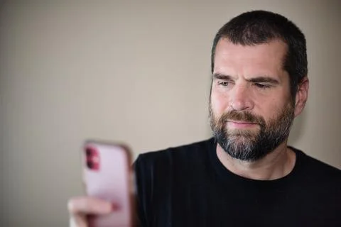 IT Guy Looking at Cell Phone - Small Smile Stock Photos