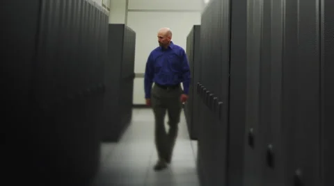 IT Guy Walks Rack Mounted Servers Stock Footage 62903759