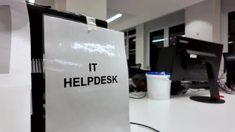 IT helpdesk sign on a desk offering technology support in an empty office Stock Footage 325838793