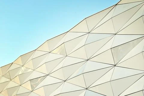 It is an irregular, twisted block covered with aluminum panels. Stock Photos