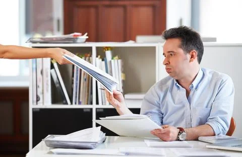 It just keeps piling up.... Shot of a mature office worker receiving a stack of Stockfoto's