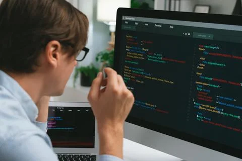 IT looking at online software development on pc align working laptop. Pecuniary. Stock Photos