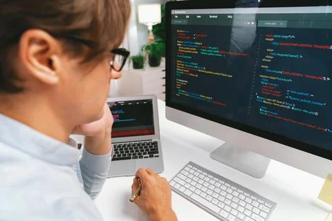 IT looking at online software development on pc align working laptop. Pecuniary. Stockfoto's