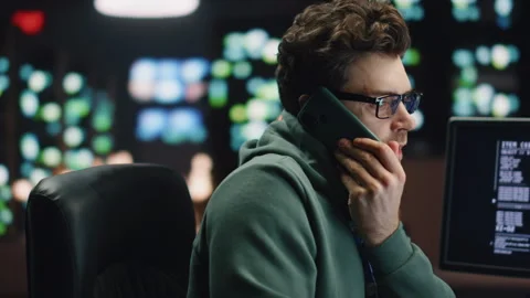 IT man talking cellphone coding computer at workplace closeup. Coder guy calling Stock Footage 260247185
