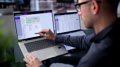 IT Manager Reviews Compliance Dashboard On Dual Touchscreen Laptop Video stock 340996448