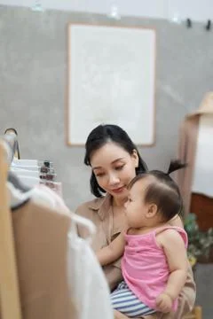It is not easy to be a working mom! Young beautiful designer  working on her Stock Photos