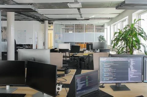 IT office and monitors with software code on them 스톡 사진