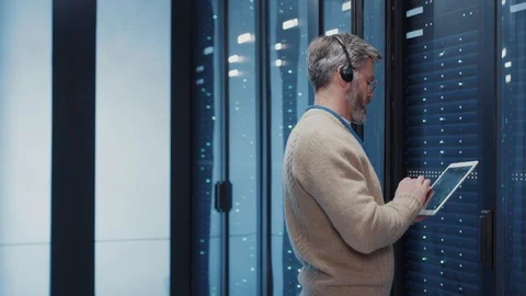 IT operators manager wearing headset for commands examining system security in Stock Footage 125404680