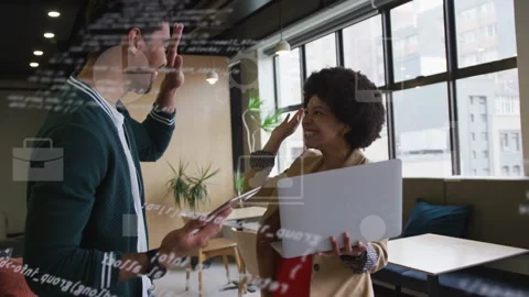 IT pair tapping tablet, scrolling laptop in lounge, code icons over screens Stock Footage 333145714