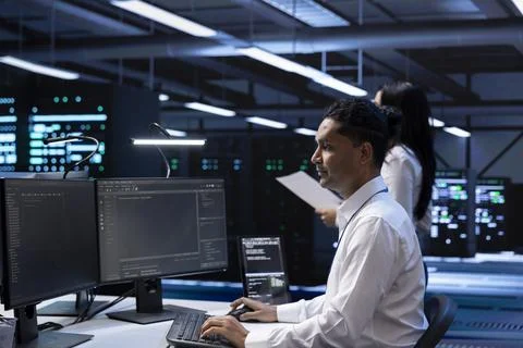 IT professional doing maintenance on storage devices in servers farm Stock Photos