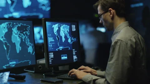 IT professional in glasses is working on computer in cyber security center Stock Footage 59376015