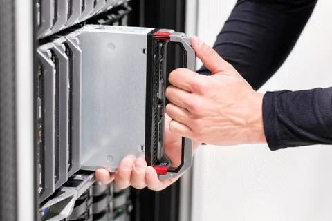 IT professional installs server cluster in large datacenter Stock Photos