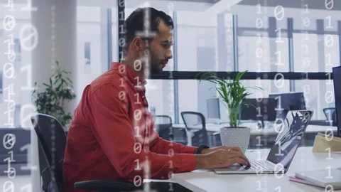 IT professional typing on laptop at desk, initiating binary overlays over Stock Footage 335739601