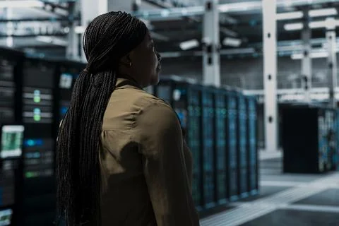 IT professional walking in data center with mainframes supporting business needs Stock-Fotos