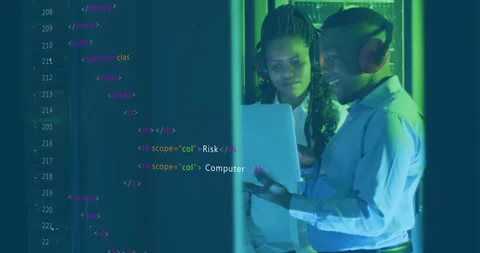 IT professionals holding laptop and scrolling code overlay while reviewing Stock Footage 313509526