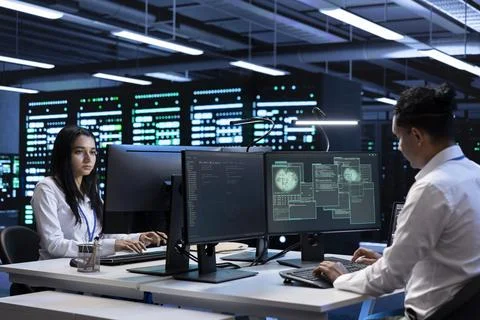 IT professionals inspecting data center supporting worldwide network Stock Photos