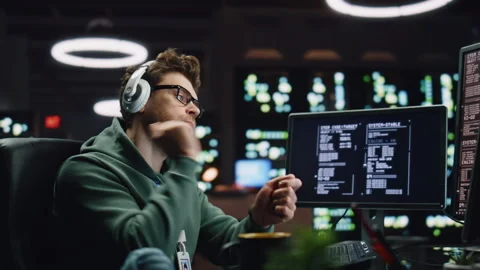 IT programer listening headphones working desktop computer data center closeup Stock Footage 260242511