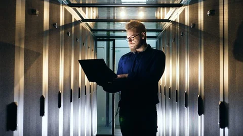 IT programer working in Data Center. Support engineer is analyzing servers with Stock Footage 115660090