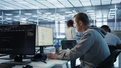 IT programmer arriving at work in data center, sitting at PC desk Stock Footage 319273392