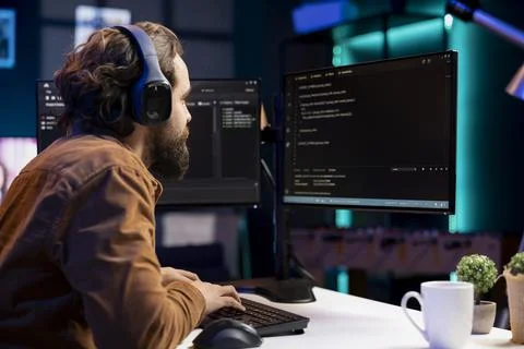 IT programmer listening music while fixing vulnerabilities in software Stock Photos