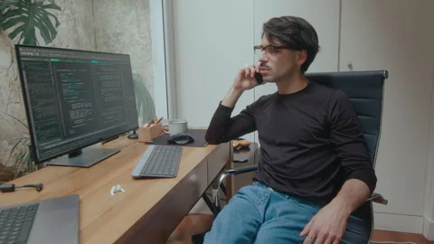 IT Programmer Looking at Computer Code and Calling on Phone Stock Footage 252751483