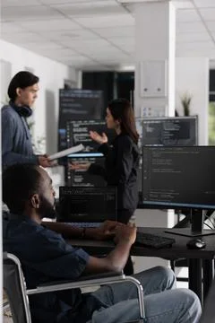 It programmer in wheelchair typing html code in coding office Stock Photos