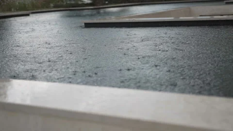 It is raining outside. Raindrops fall into the water. Slow motion. Close up Stock Footage 103972725