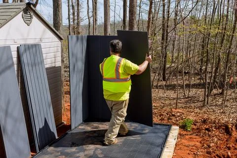 It is responsibility of worker to assemble together plastic shed near home for Stock-Fotos