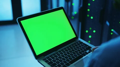 IT server expert using mock-up blank laptop with green monitor, programming data Stock Footage 121116656